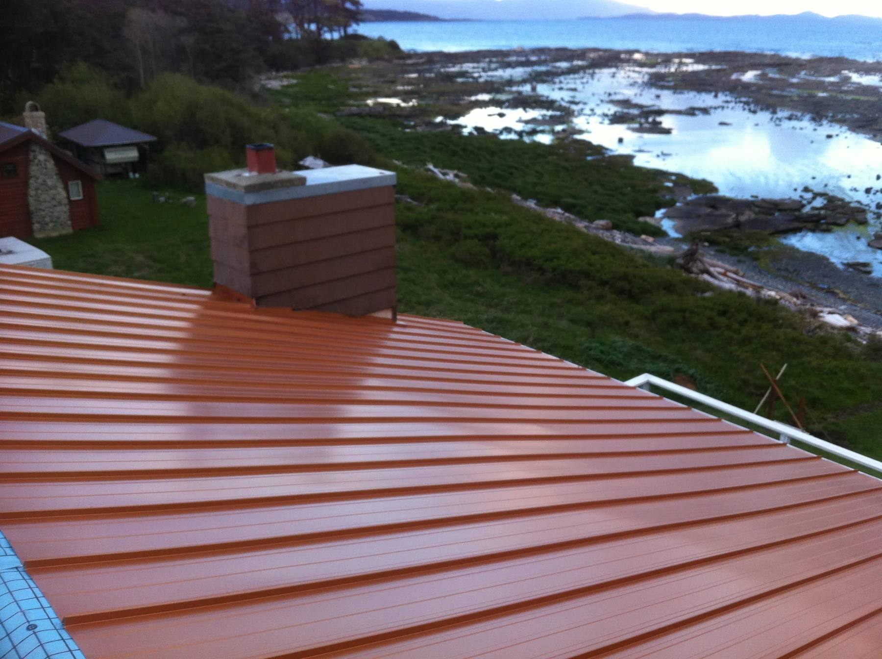A red standing-seam roof overlooking the shoreline.