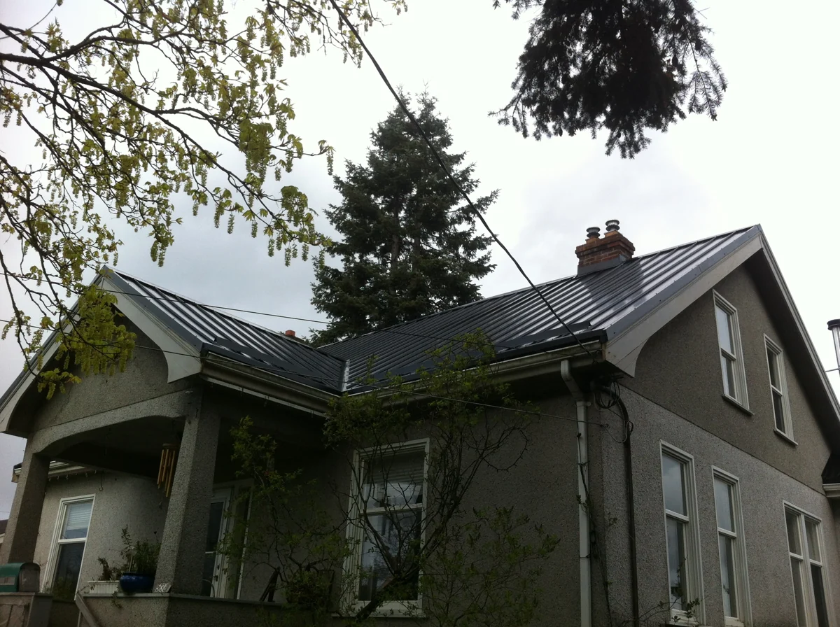 Green house with a dark metal roof from the Square Deal gallery