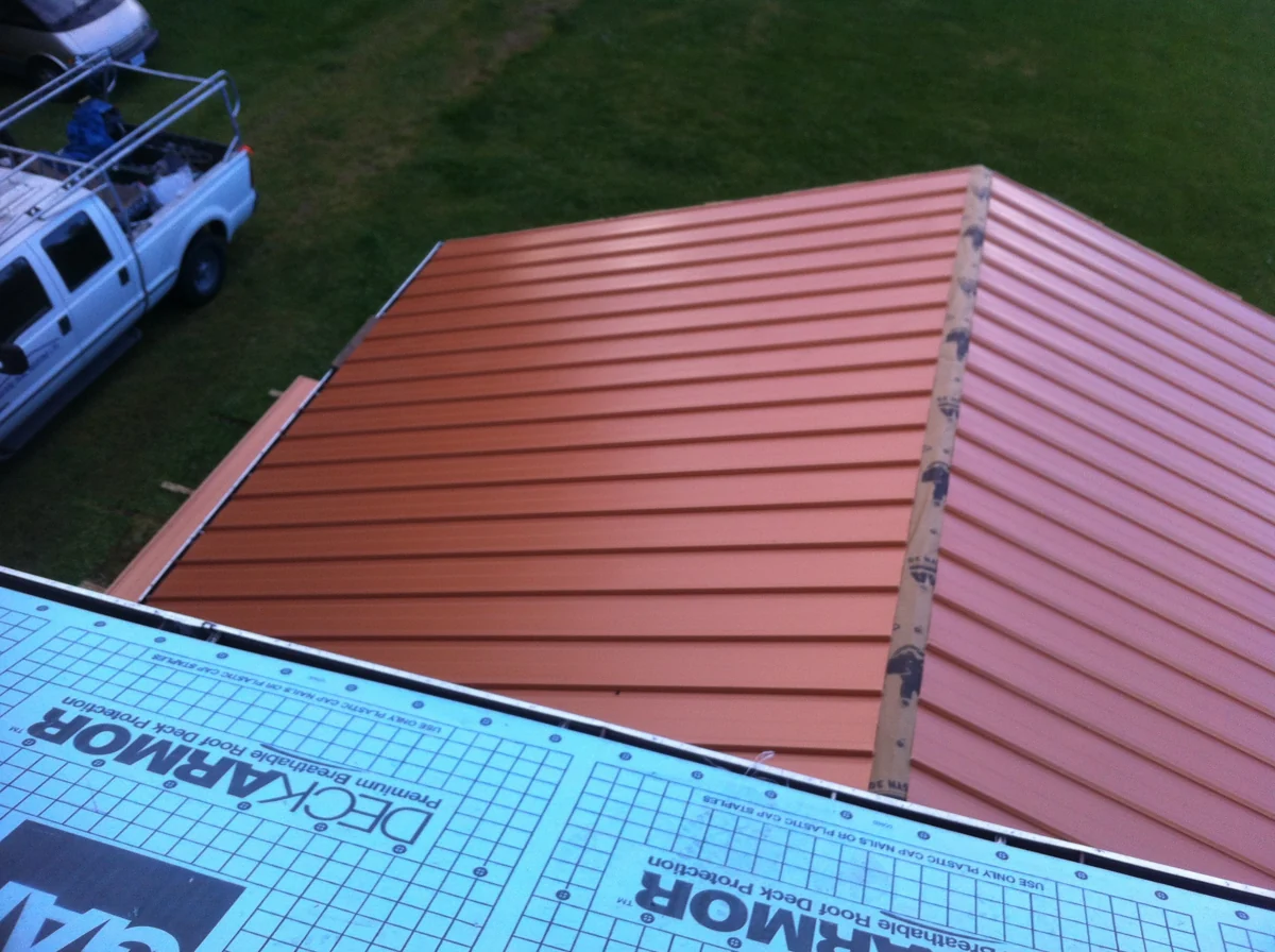 Close view of red metal roof seams and edge construction